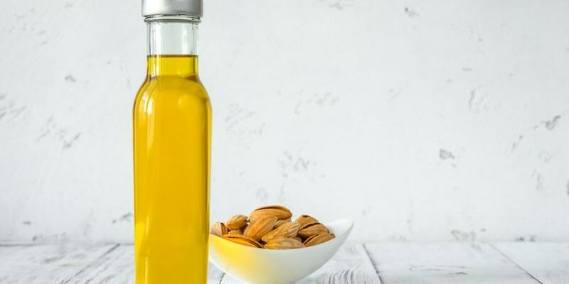 Bottle of almond oil with almonds